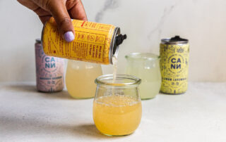 Person Pouring COntent from Yellow Can into Glass Person Pouring Content from Yellow Can into Glass